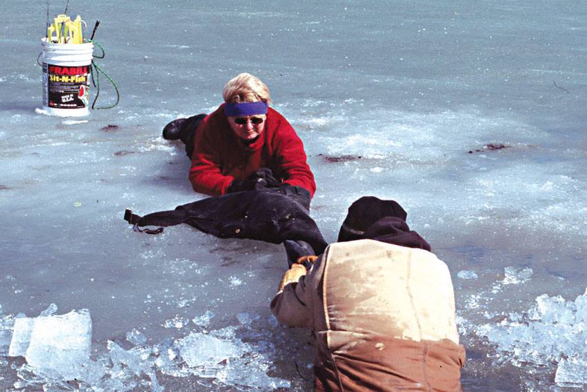 Woman pulling man who fell throught the ice out of the water